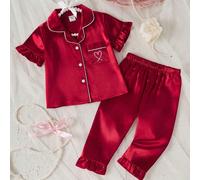 1 Set Pigiama Bambina con Elegante Colletto a Revers e Top a Maniche Corte Abbinato a Pantaloni Lunghi Coordinati. Questa Morbida Biancheria da Notte Leggera Simile al Raso è in Rosso Vivace con Bordi