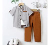 2 pezzi Outfit scolastico per bambini, camicia a maniche corte bicolore grigio chiaro con colletto e pantaloni marroni, in tessuto lavorato. La camicia ha 5 bottoni e una tasca con bordo marrone sul p