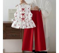 Completo da 2 pezzi con stampa a ciliegie per ragazze pre-adolescenti, top corto senza maniche con vita stretta e pantaloni a gamba larga coordinati. Il top bianco è stampato con motivi a ciliegie gio