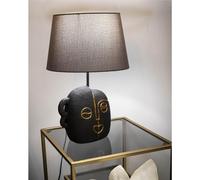 Lampada da tavolo in resina dalla forma ispirata ad un volto tribale Dimensioni 30,5xh 46 cm in resina e paralume in tessuto grigio oro