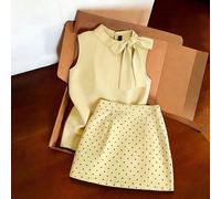 Outfit da pendolare grigio chiaro, top senza maniche con collo alto abbinato a minigonna a pois. Silhouette aderente minimalista che valorizza la vita. Tessuto morbido e fluido. Il fiocco sul top e i 