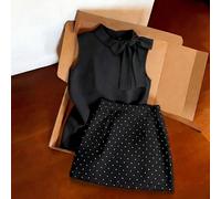 Outfit da pendolare grigio chiaro, top senza maniche con collo alto abbinato a una minigonna a pois. Silhouette aderente minimalista che valorizza la vita. Tessuto morbido e fluido. Il fiocco sul top
