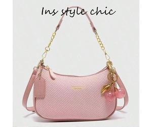 Questa borsa alla moda e impermeabile in PU presenta un design a tinta unita, con una tracolla a forma di mezzaluna e un delicato ciondolo a forma di ciliegia. Può essere utilizzata come borsa da pend
