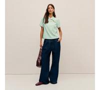 Questa camicetta femminile presenta un colletto alto con elementi ispirati alla Cina. Tre bottoni aggiungono un tocco orientale. La silhouette a maniche corte e linea dritta, insieme al taglio pulito,