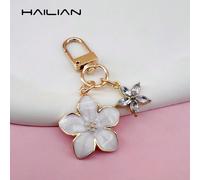 Questa elegante e leggera portachiavi a forma di sakura è realizzata in lega progettata appositamente per le donne, e viene fornita con un ciondolo a forma di piccolo fiore a 5 petali. Accessorio da v