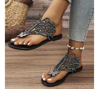 Questo è un paio di ciabatte da donna piatte, con uno stile piuttosto raffinato e lussuoso. Sulla parte superiore delle scarpe ci sono motivi traforati e molti cristalli incastonati. C'è anche una dec