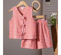 Questo è un set composto da due articoli: un gilet smanicato lavorato a maglia a quadri per ragazze e pantaloncini larghi e casual. Il gilet è decorato con un fiocco e i pantaloncini hanno una vita el