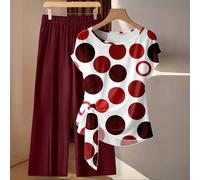 Set casual minimalista da 2 pezzi composto da una blusa rossa con stampa a pois su tutto il capo e laccetti frontali abbinata a pantaloni verdi larghi e dritti, adatto per vacanze primaverili/estive L