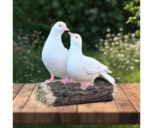 Statua di due piccioni bianchi in piedi su un ceppo d'albero per il