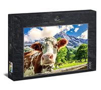 Ulmer Puzzleschmiede - Puzzle "Traum-Kuh-Lisse" - 2000 pezzi di puzzle Alpi - la mucca curiosa in primo piano come puzzle fotografico davanti a uno sfondo di montagna da sogno nella regione alpina